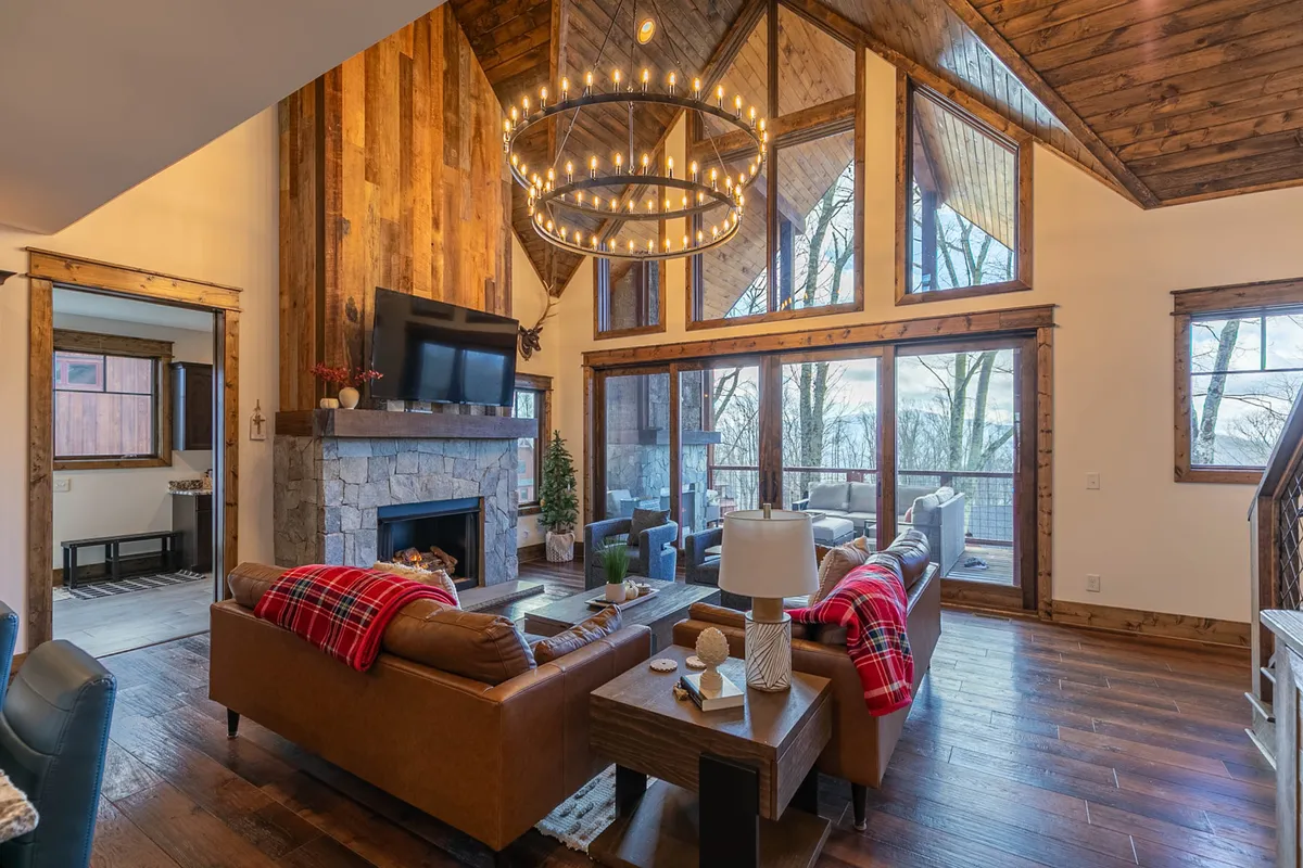 A welcoming lounge area accented by a striking fireplace, large windows that frame picturesque outdoor scenery, and plush couches with red blankets. The room radiates warmth and hospitality, encouraging relaxation after a day of adventure.